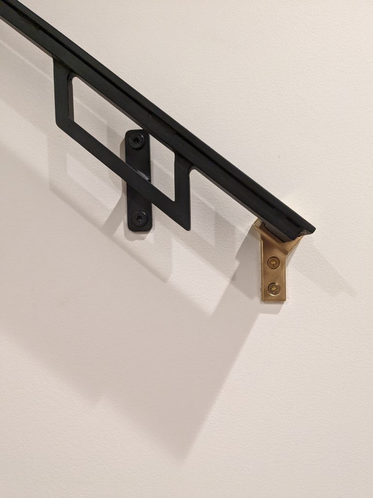 Milled brass handrail bracket on custom flat bar steel handrail, Minneapolis stair installation