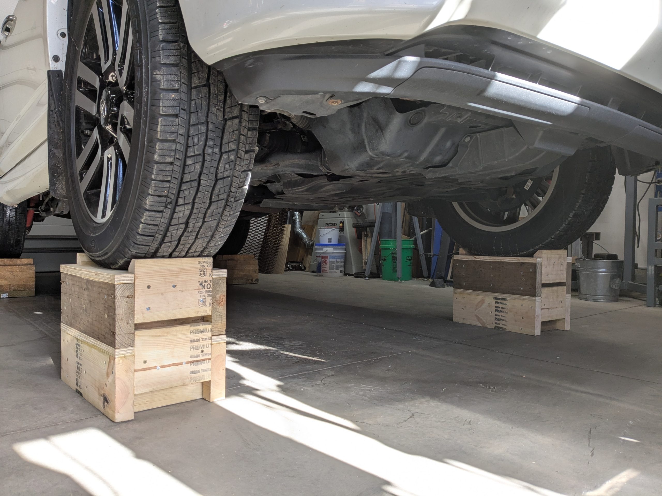 Two wheel cribs stacked under a vehicle tire